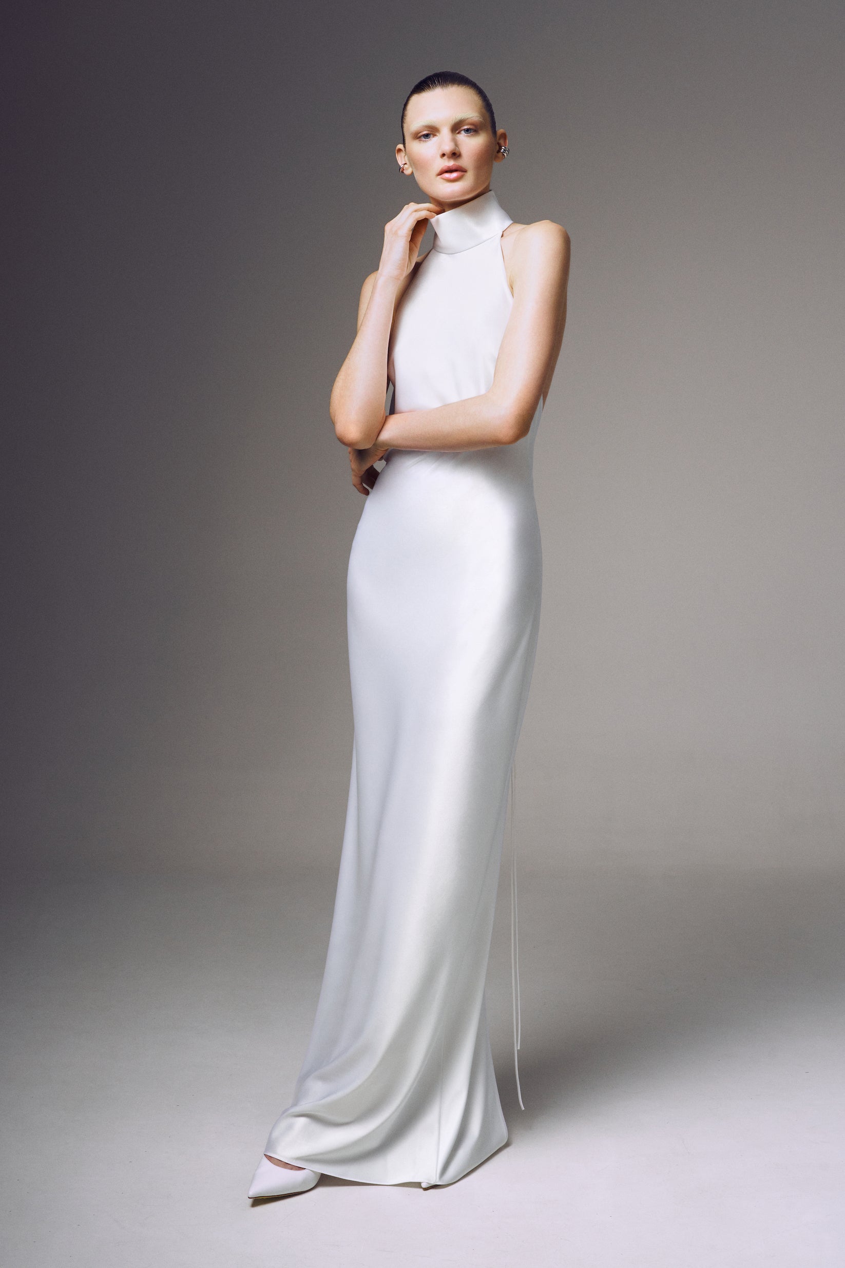 Devon Dress by J'amemme — model wearing white halter-neck bridal gown, front view showcasing sleek floor-length silhouette
