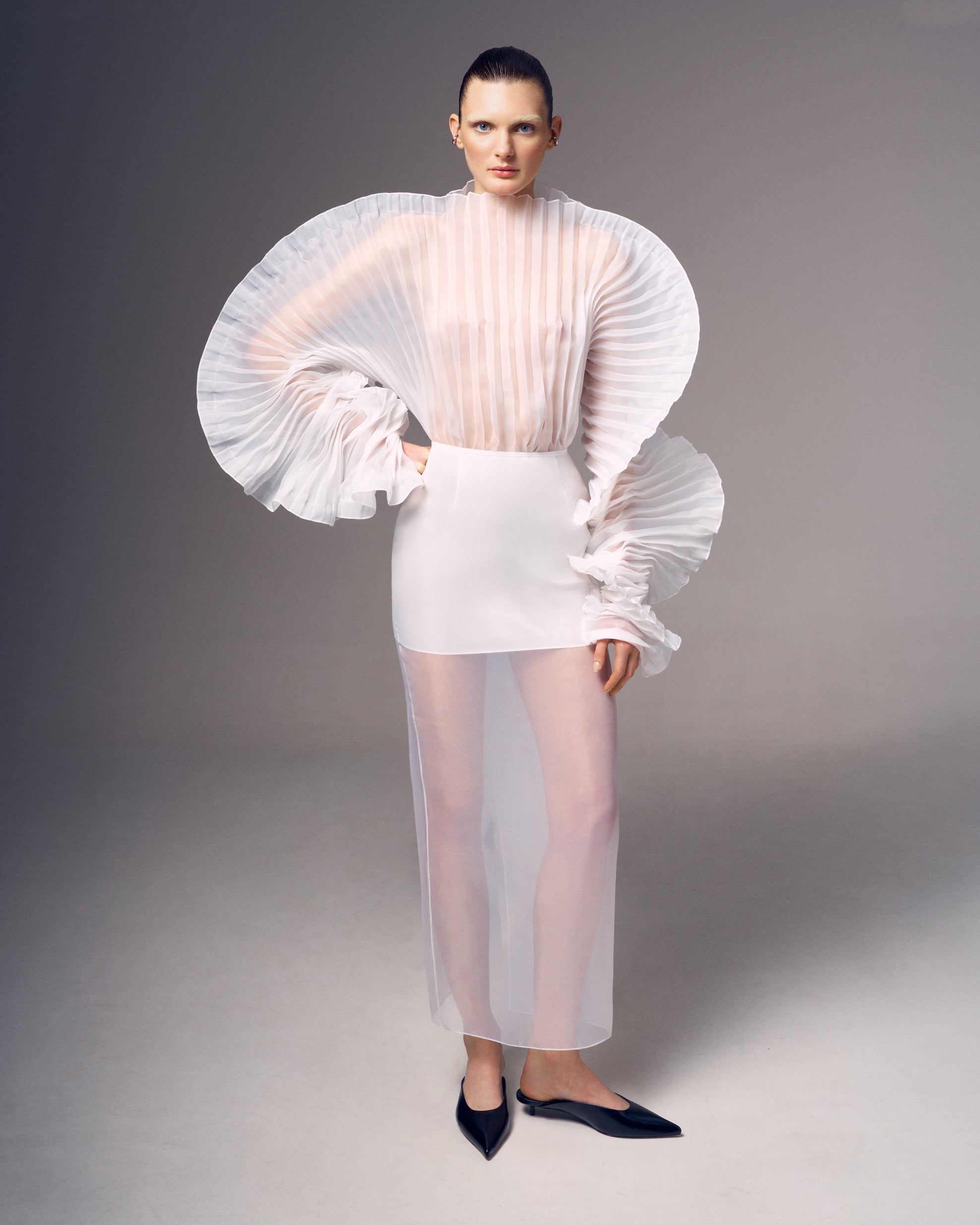 Fleur Set by J'amemme — model wearing white pleated bridal two-piece, full-length editorial shot