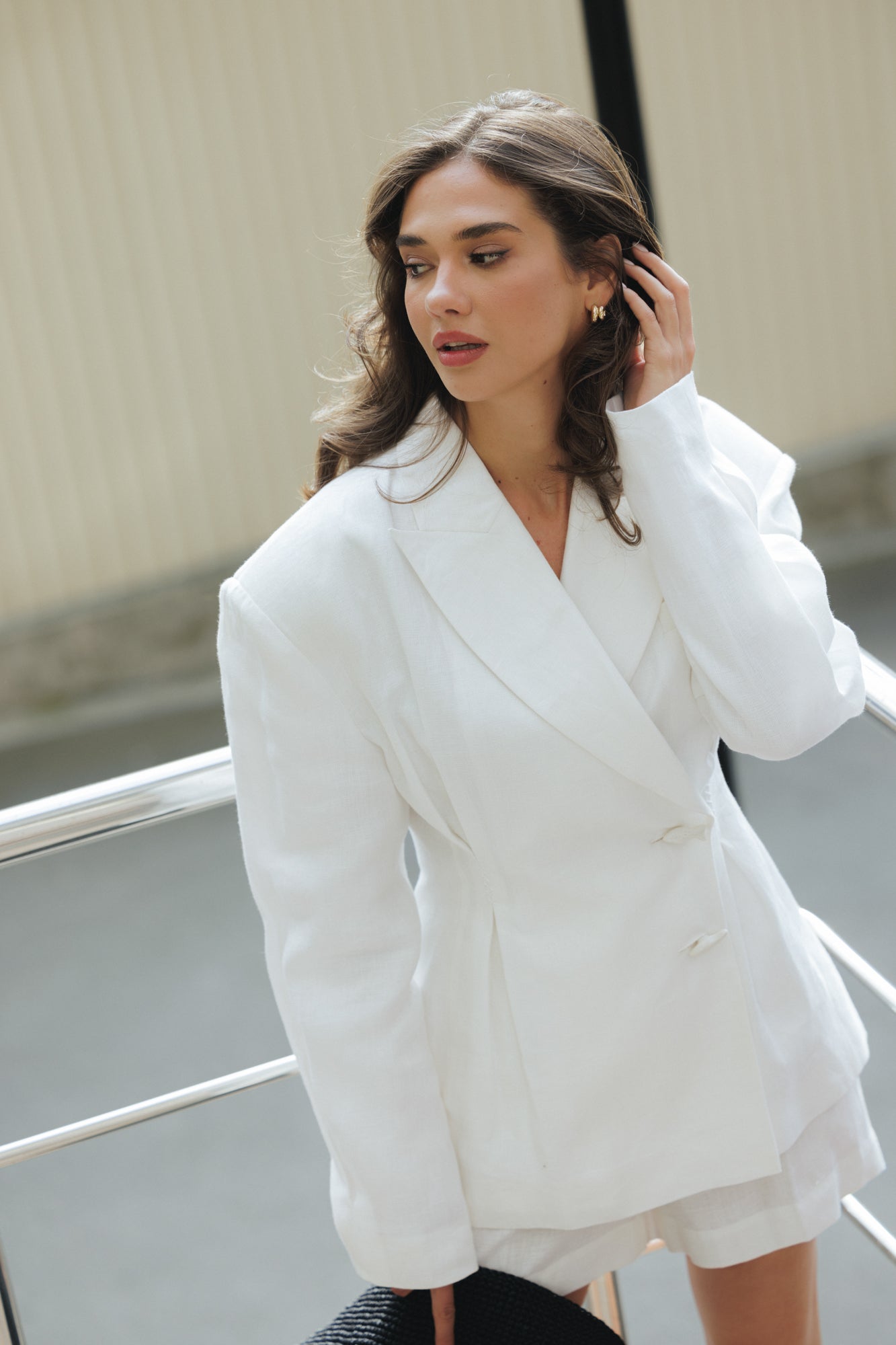 Close-up portrait of a model wearing the Jamemme Halkidiki White linen jacket and shorts set