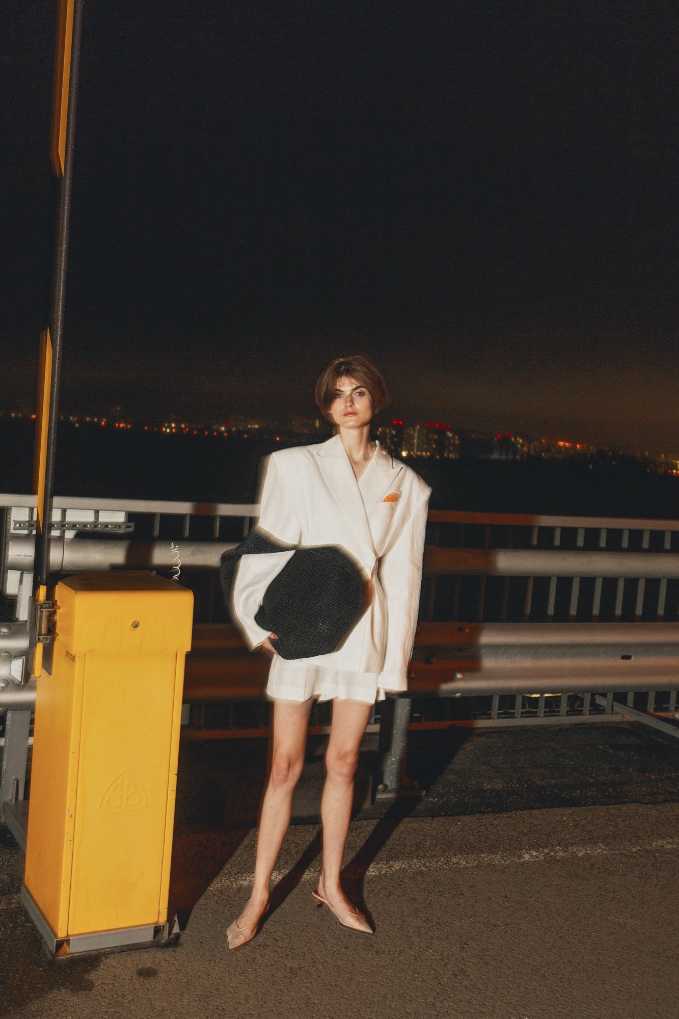 Model wearing Jamemme Halkidiki White Shorts and matching linen jacket, night outdoor styled shot