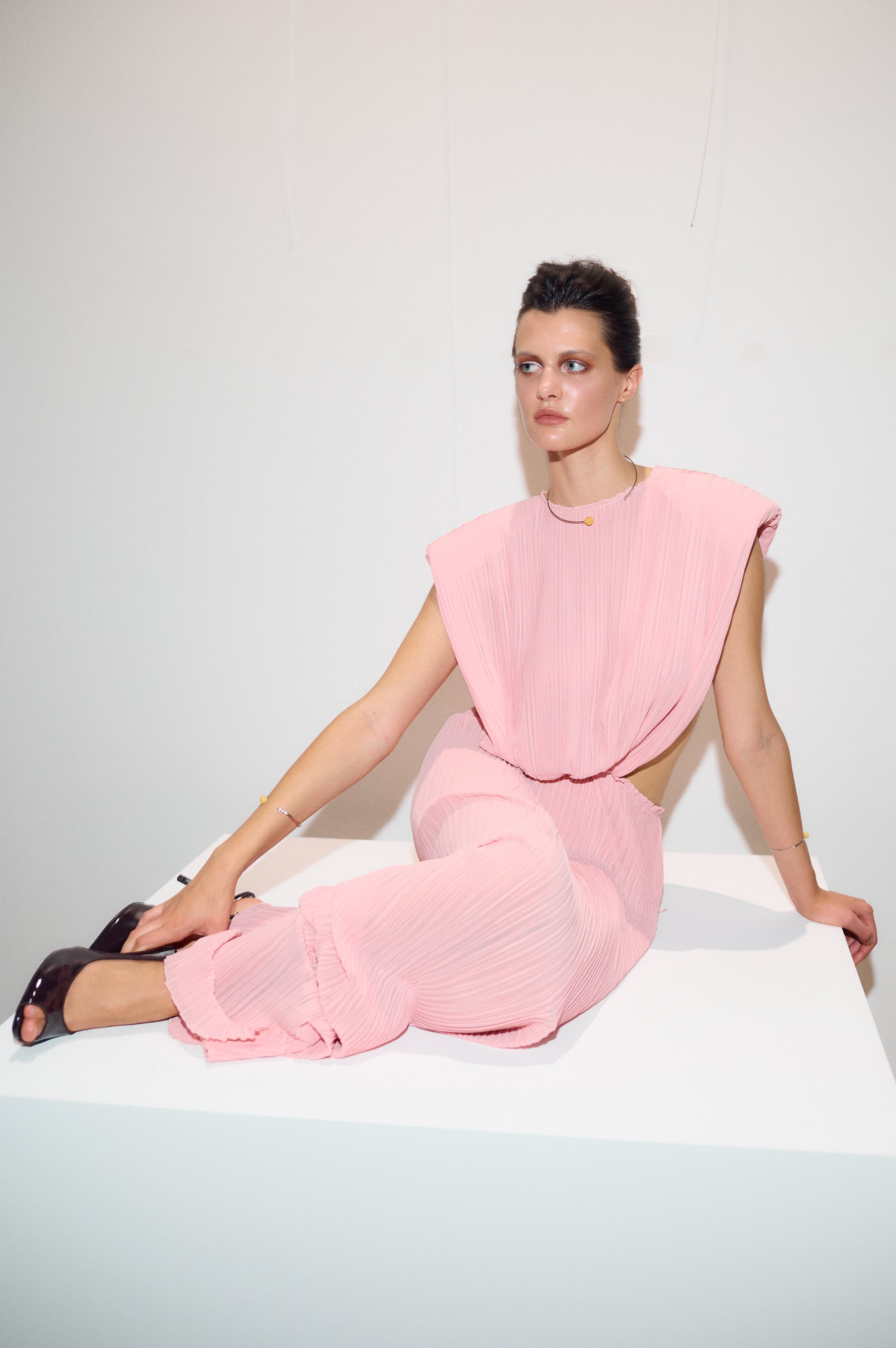 Model seated wearing Jamemme Greek Chiffon Dress in pink with matching slip skirt, SS26 collection