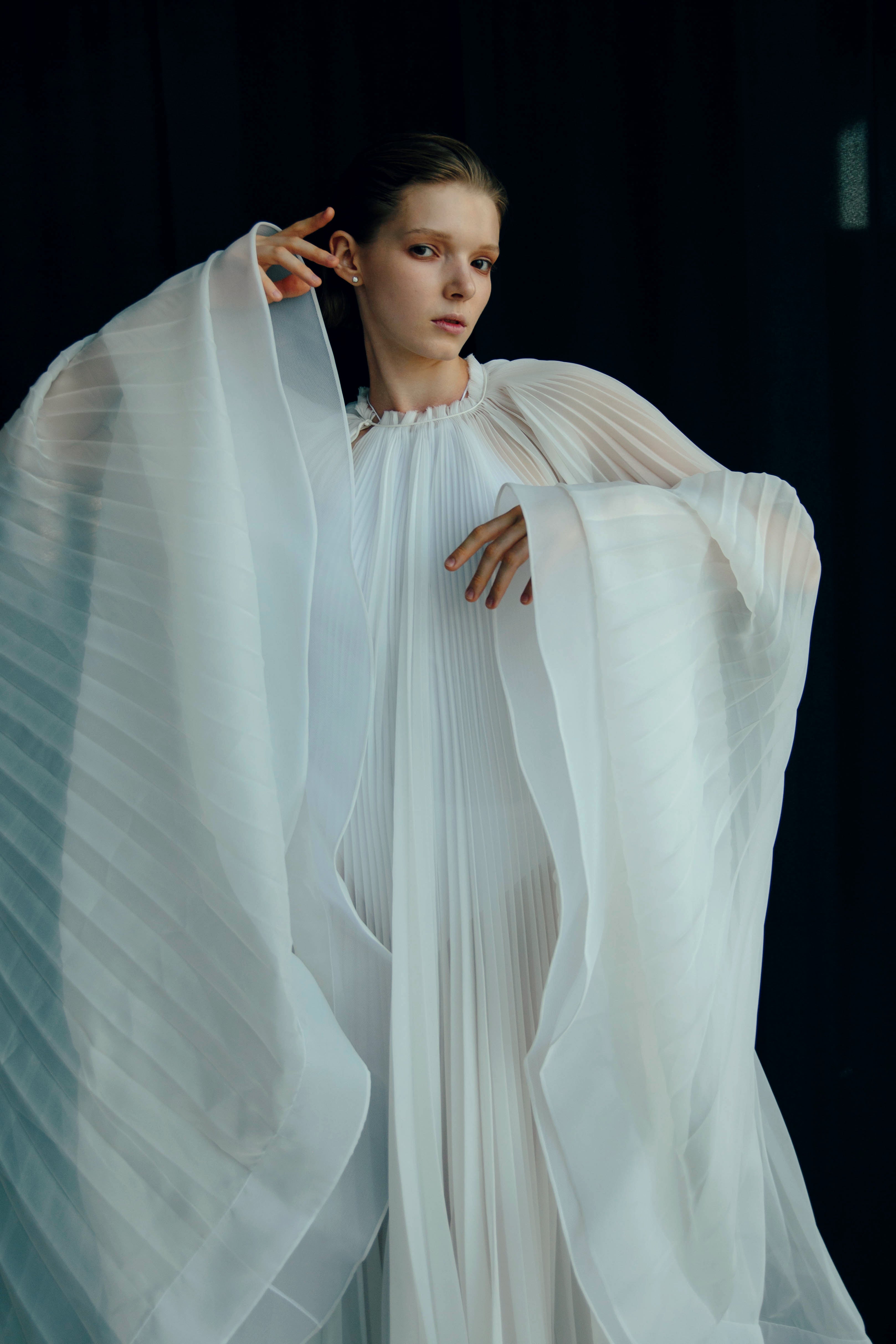 Virgin Dress by J'amemme — close-up of model showing dramatic cape drape of white pleated bridal gown
