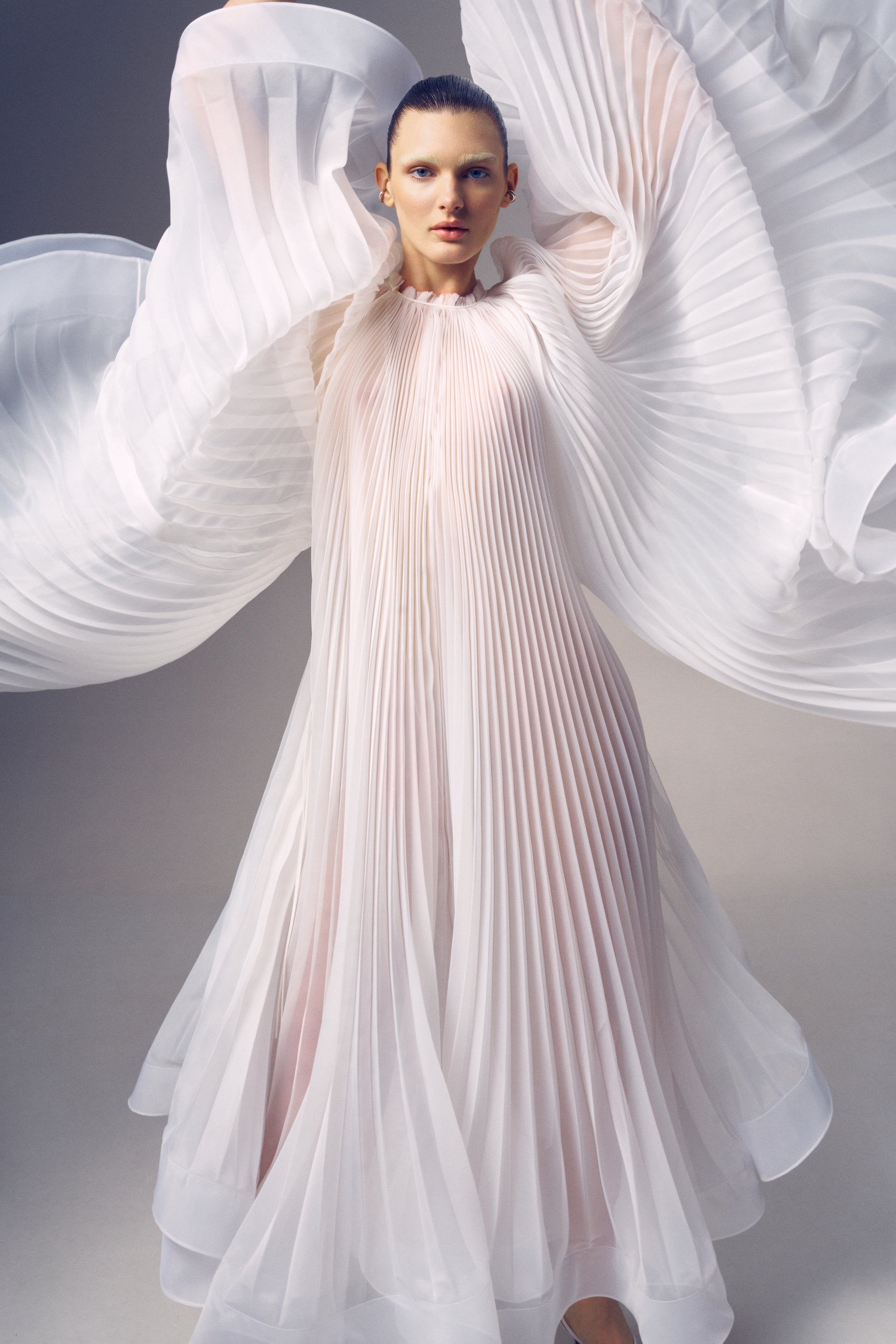 Virgin Dress by J'amemme — front view with pleated cape spread wide like wings, showcasing dramatic movement and ethereal silhouette