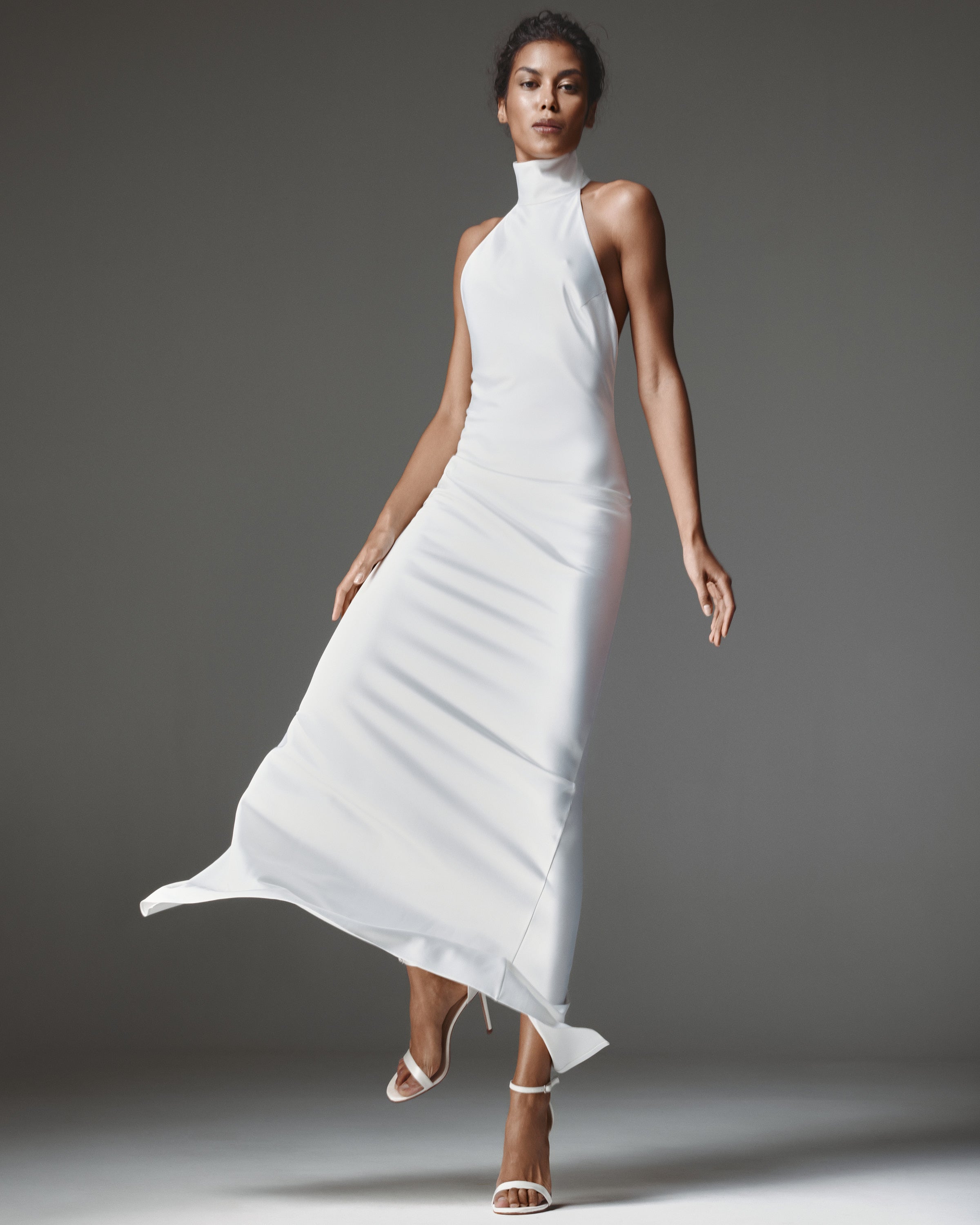 Devon Dress by J'amemme — model wears the white satin halter wedding gown with high stand collar, front view; sleeveless floor-length minimalist bridal column.
