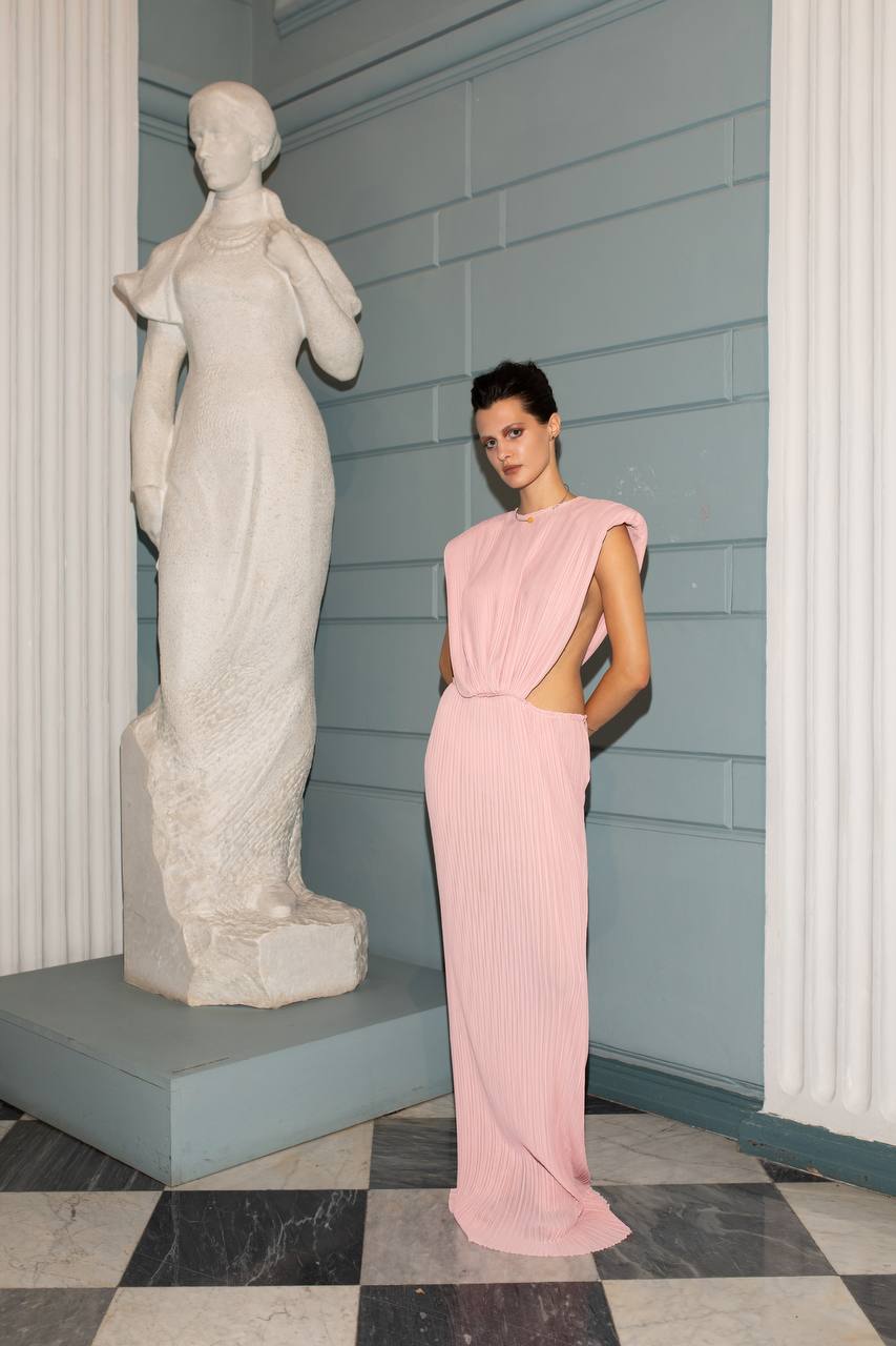Model wearing Jamemme Greek Chiffon Dress in pink - hourglass silhouette, shoulder pads, side cutouts, SS26
