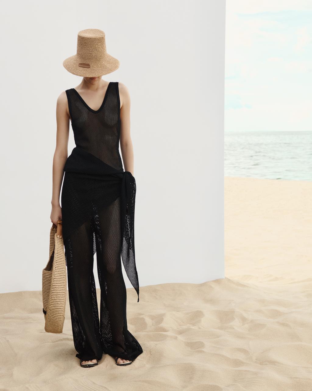 Model wearing the black Nereis open-knit set, top and trousers — J'AMEMME Resort '27