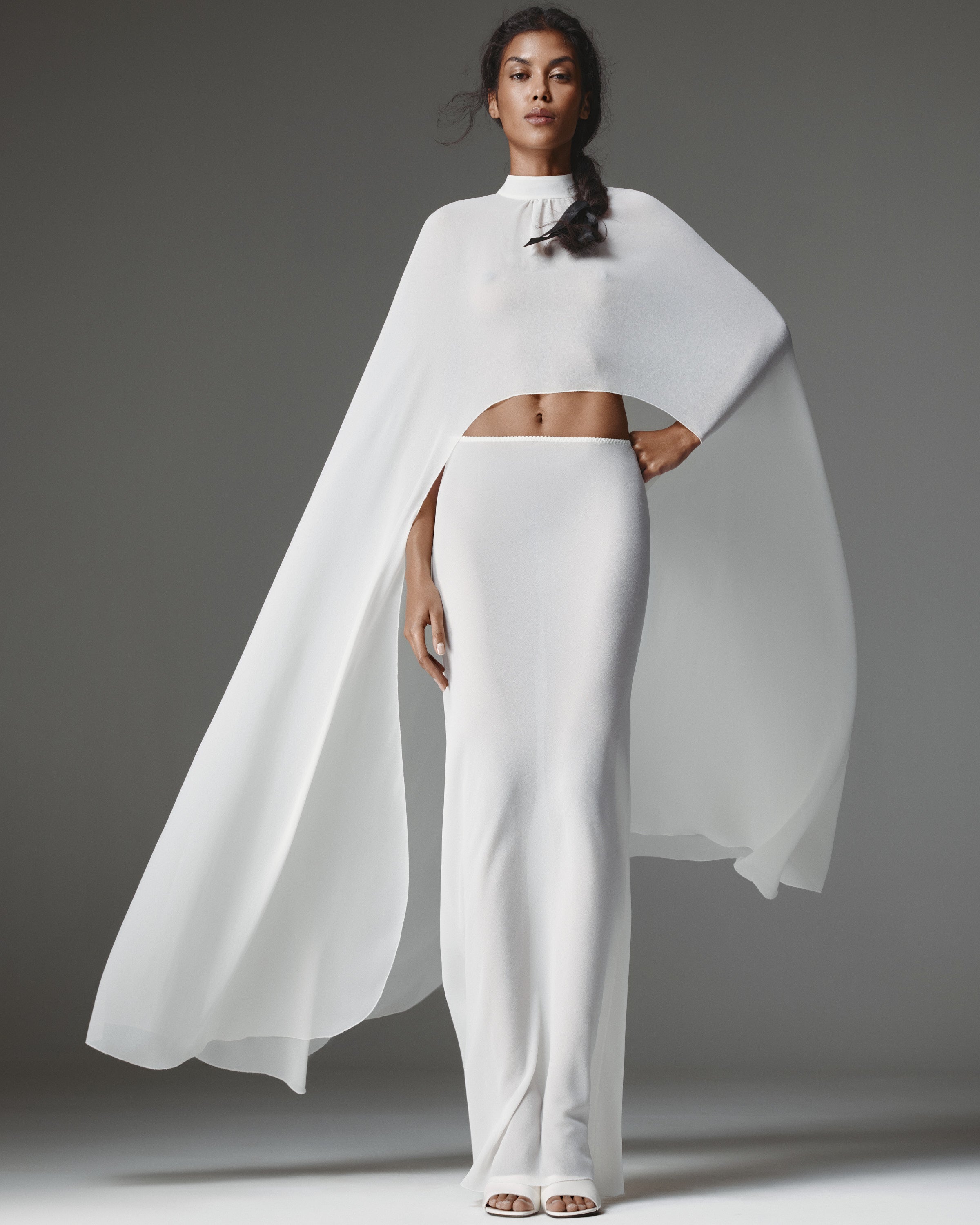 Patrizzia by J'amemme — sheer white chiffon cape worn over the matching column skirt, front view.