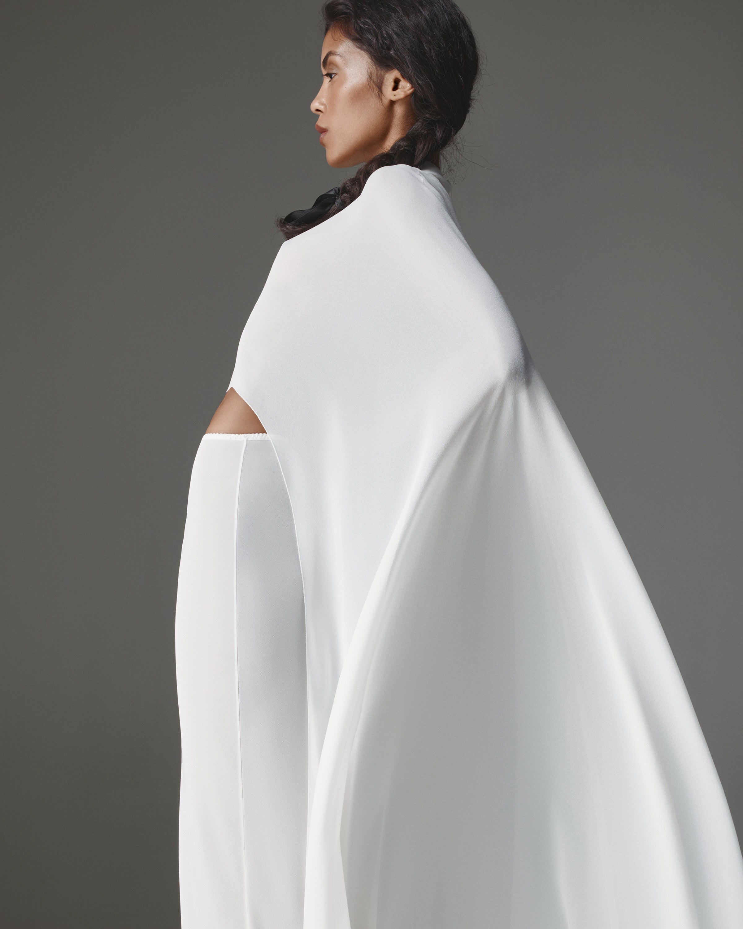 Patrizzia by J'amemme — sheer white chiffon cape worn over the matching column skirt, side view.